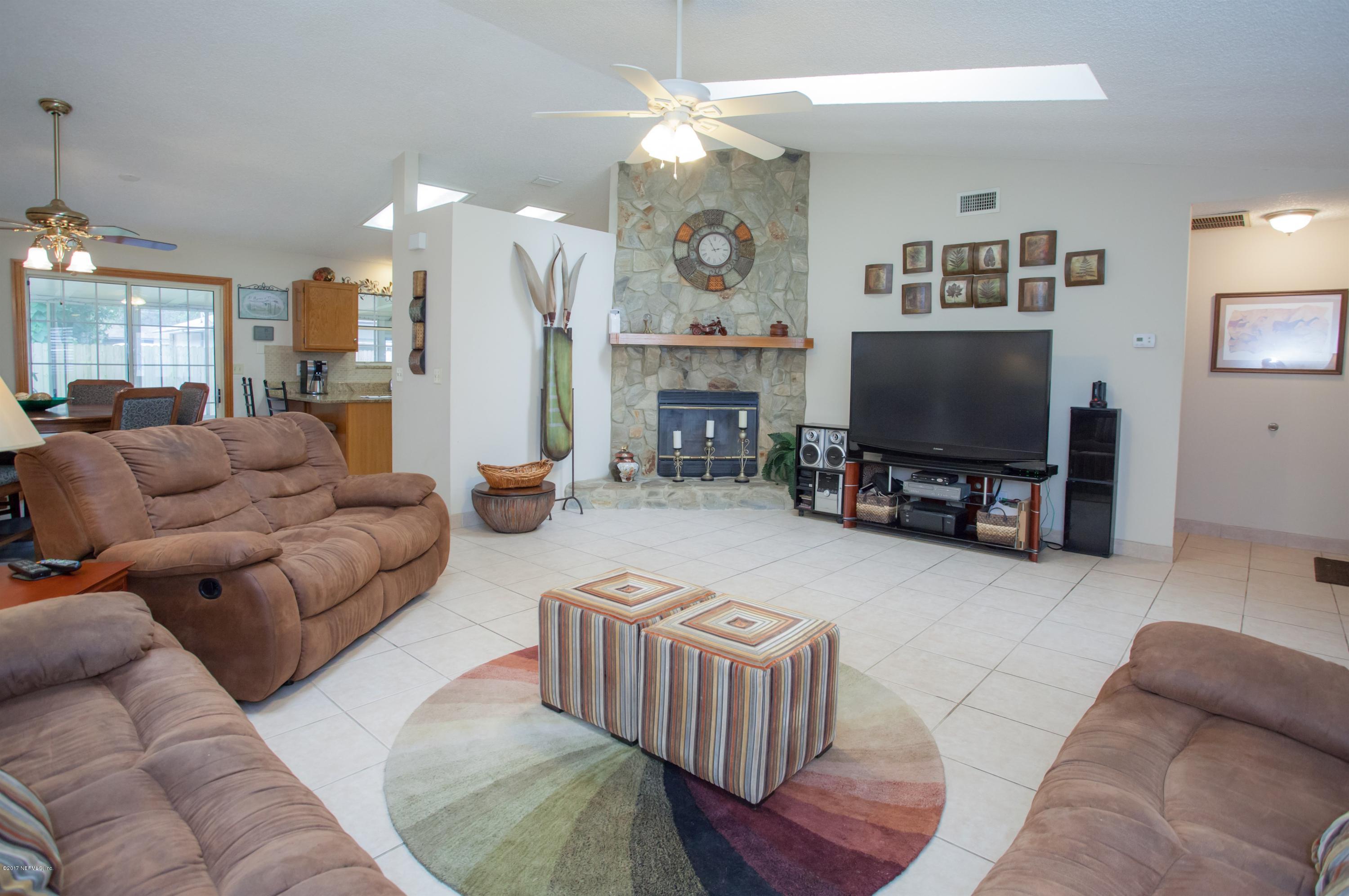 118 Pelican Road St. Augustine, FL 32086 - Photo 5 of 25 a living room with furniture a fireplace and a flat screen tv