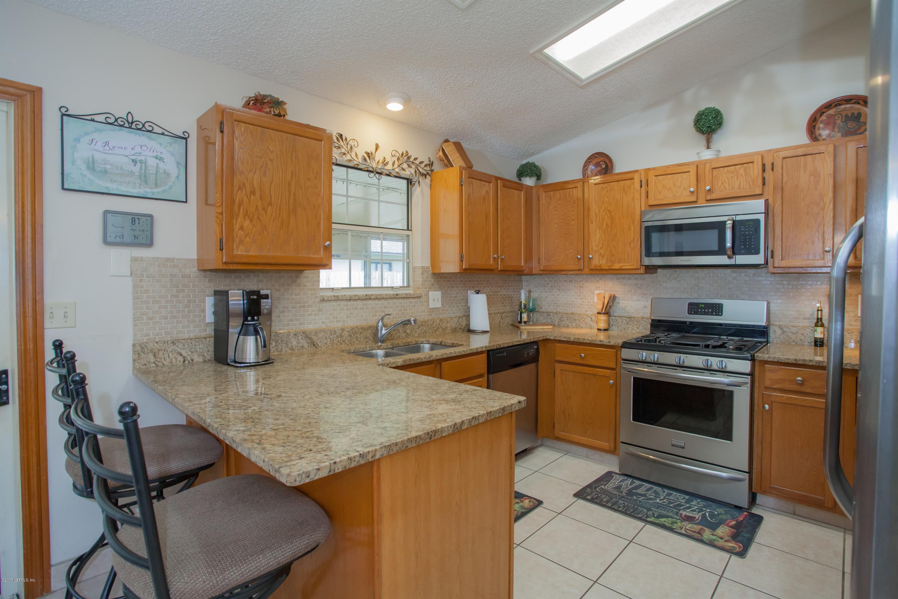 118 Pelican Road St. Augustine, FL 32086 - Photo 10 of 25 a kitchen with a stove a sink and a microwave