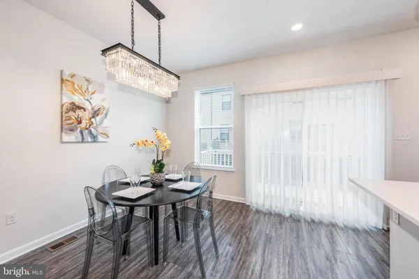 an open kitchen with wooden floor and stainless steel appliances
