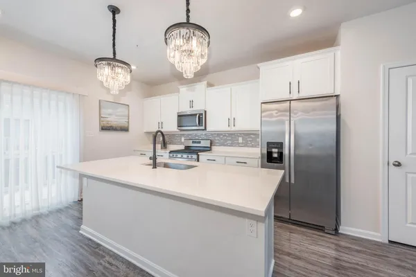a view of a kitchen with stainless steel appliances granite countertop a sink a refrigerator and a stove
