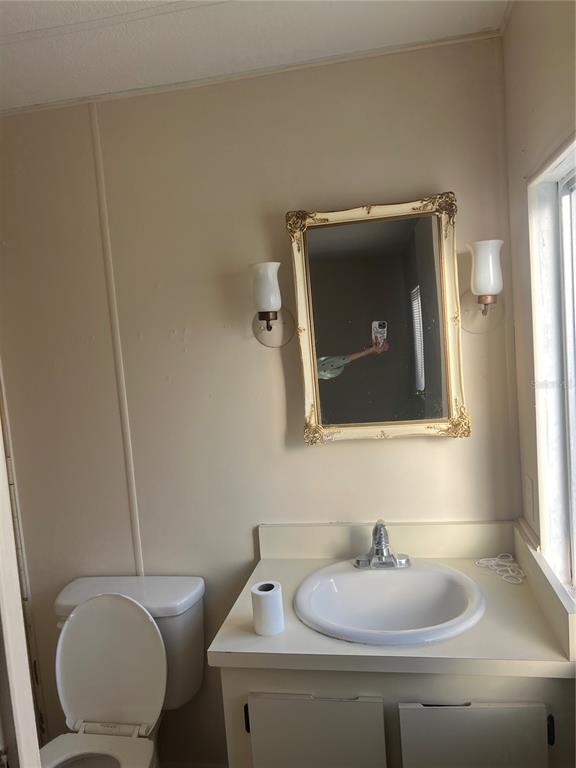 1610 Reynolds Road, Unit 87 Lakeland, FL 33801 - Photo 12 of 12 a bathroom with a toilet sink vanity and mirror