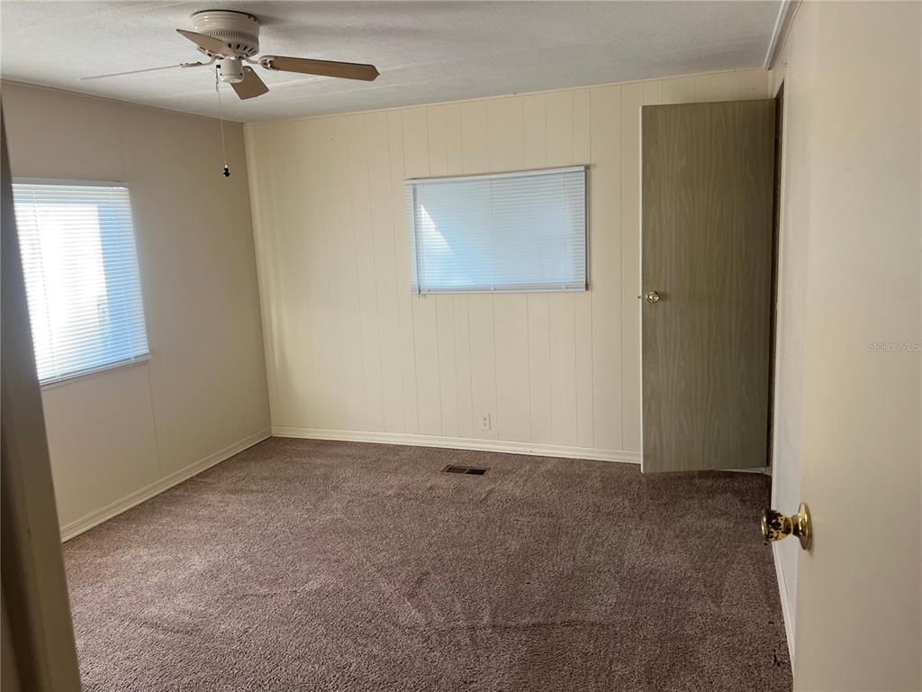 1610 Reynolds Road, Unit 87 Lakeland, FL 33801 - Photo 10 of 12 an empty room with a ceiling fan and a window