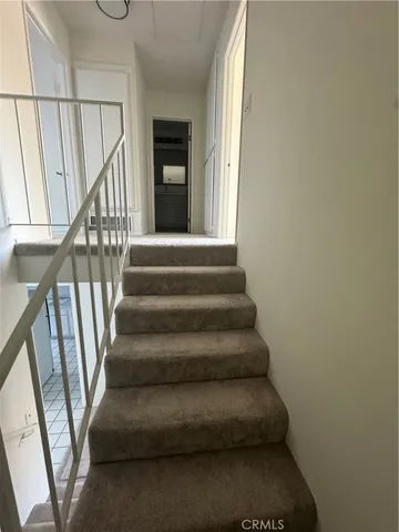 a view of staircase with lots of frames on wall