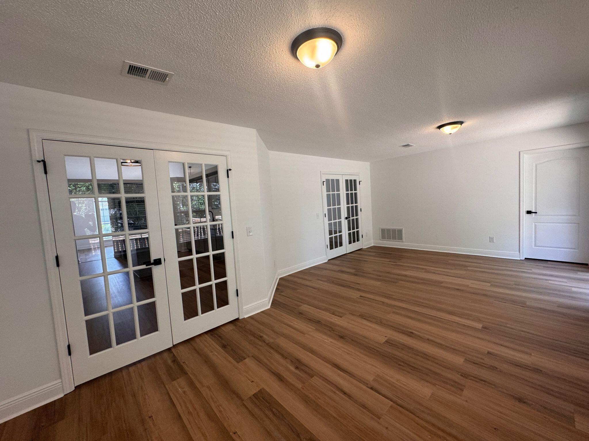 516 Vulpes Sanctuary Loop Crestview, FL 32536 - Photo 15 of 30 wooden floor in an empty room with a window