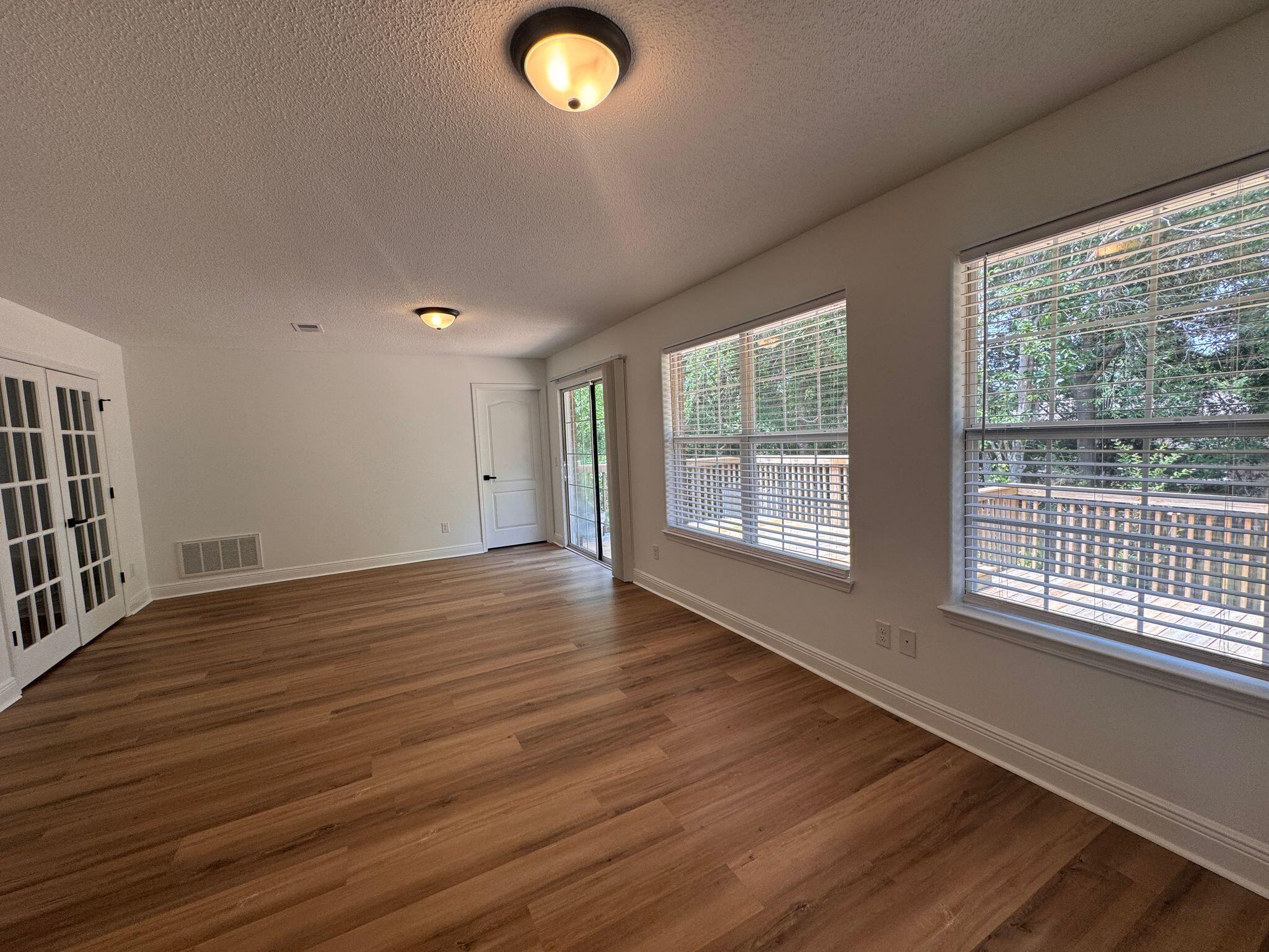 516 Vulpes Sanctuary Loop Crestview, FL 32536 - Photo 16 of 30 a view of an empty room with wooden floor and a window