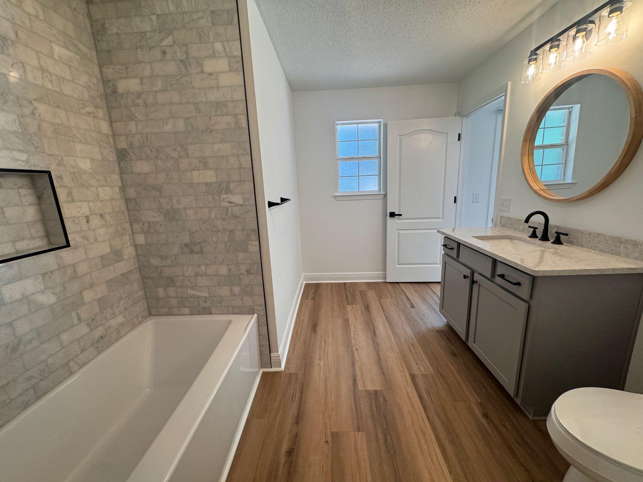 516 Vulpes Sanctuary Loop Crestview, FL 32536 - Photo 18 of 30 a bathroom with a sink a toilet a mirror and bathtub