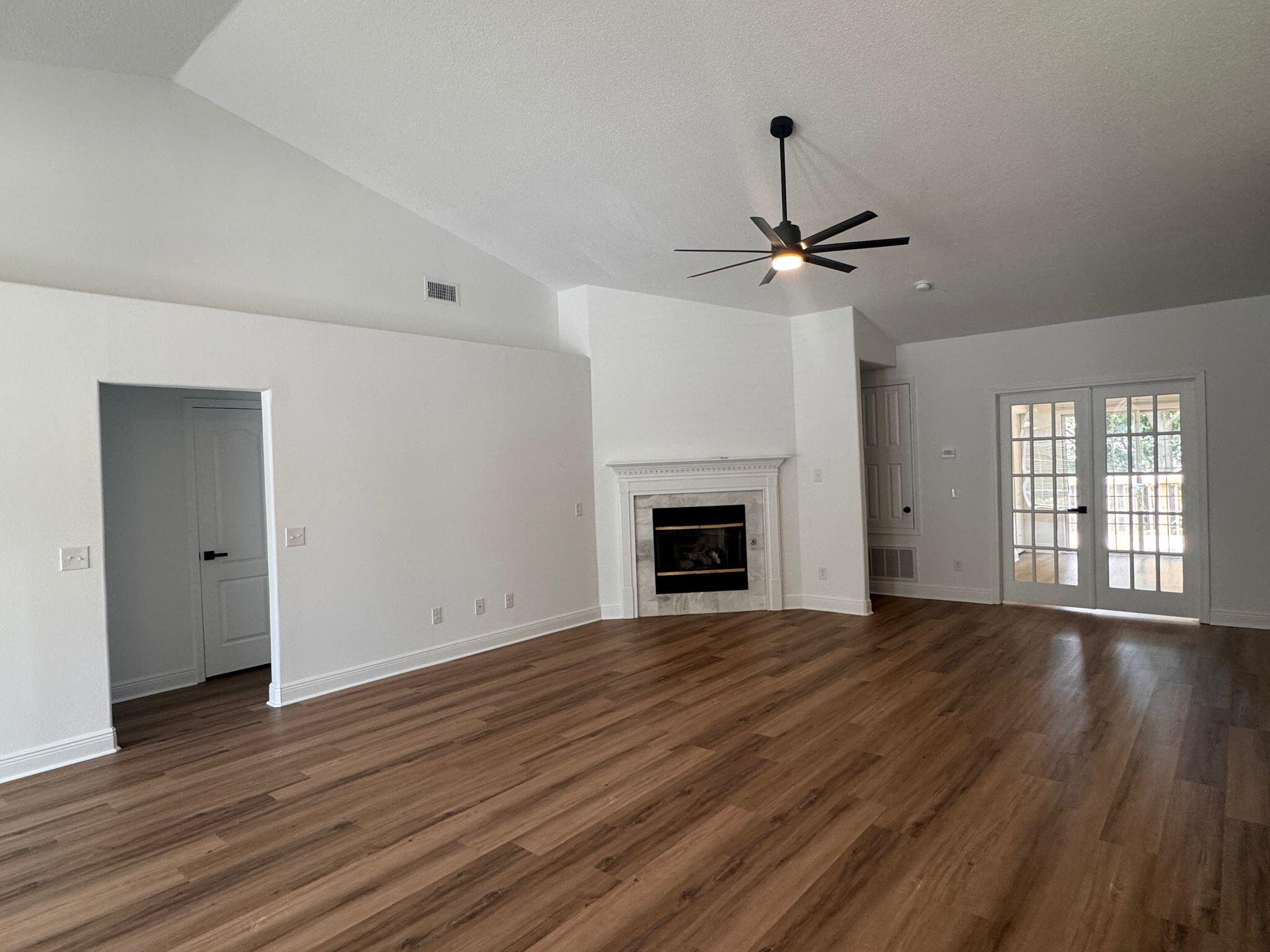516 Vulpes Sanctuary Loop Crestview, FL 32536 - Photo 5 of 30 a view of an empty room with wooden floor fireplace and a window