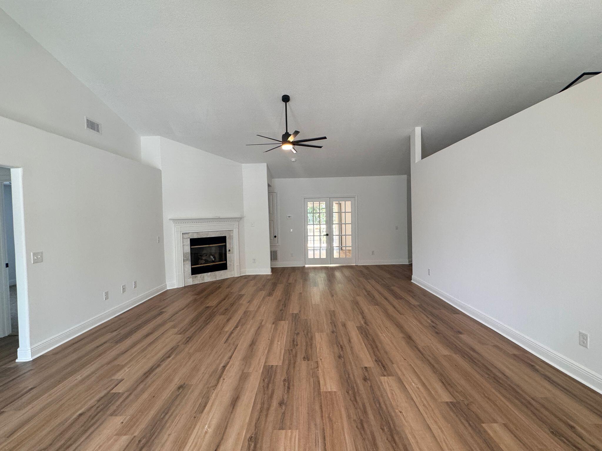 516 Vulpes Sanctuary Loop Crestview, FL 32536 - Photo 6 of 30 a view of empty room with wooden floor and fireplace