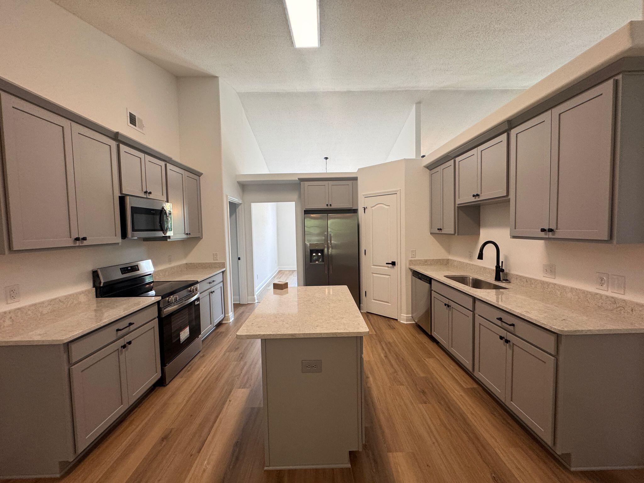 516 Vulpes Sanctuary Loop Crestview, FL 32536 - Photo 8 of 30 a large kitchen with stainless steel appliances granite countertop a lot of counter space and wooden floors