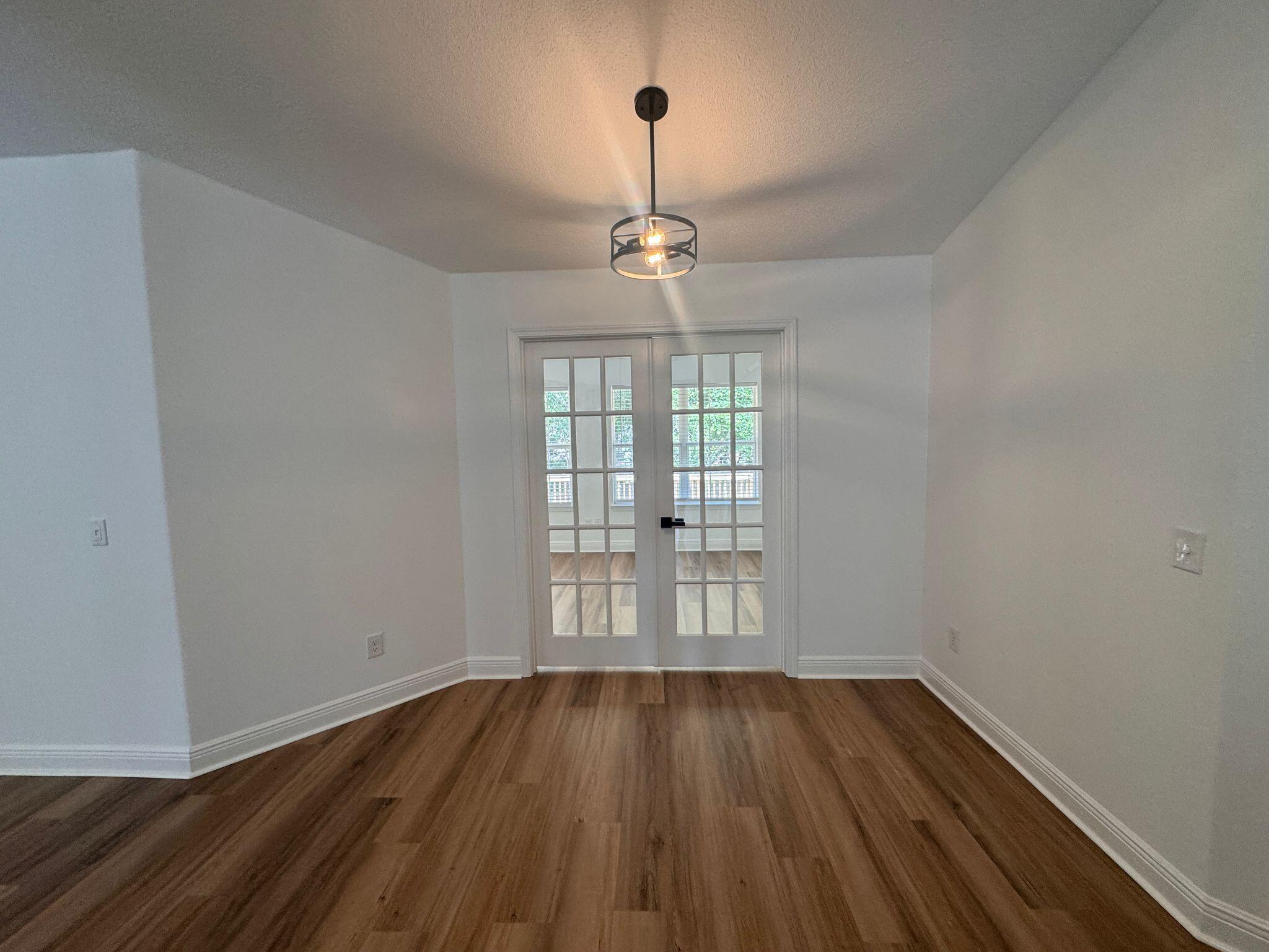 516 Vulpes Sanctuary Loop Crestview, FL 32536 - Photo 9 of 30 wooden floor in an empty room with a window