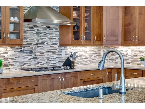 a kitchen with stainless steel appliances granite countertop a lot of counter space and wooden floors