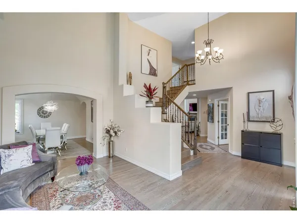 a living room with furniture chandelier and a large window