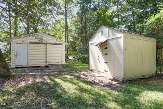 a view of a white house with a yard and large tree