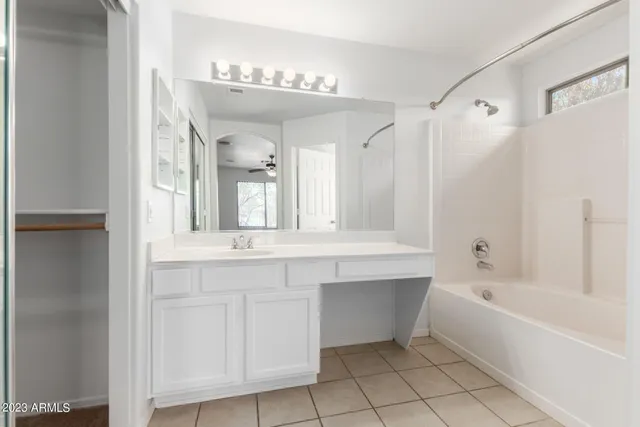 a bathroom with a bathtub sink and mirror
