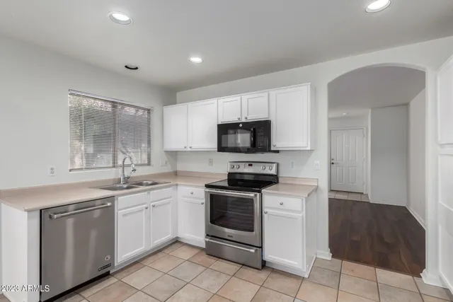 a kitchen with white cabinets stainless steel appliances and sink