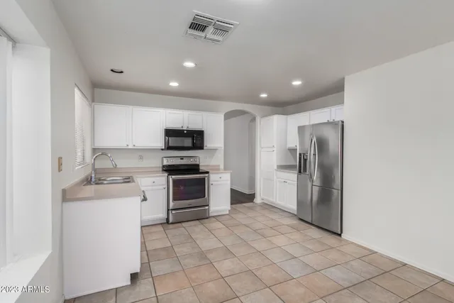 a kitchen with stainless steel appliances granite countertop a refrigerator sink and stove