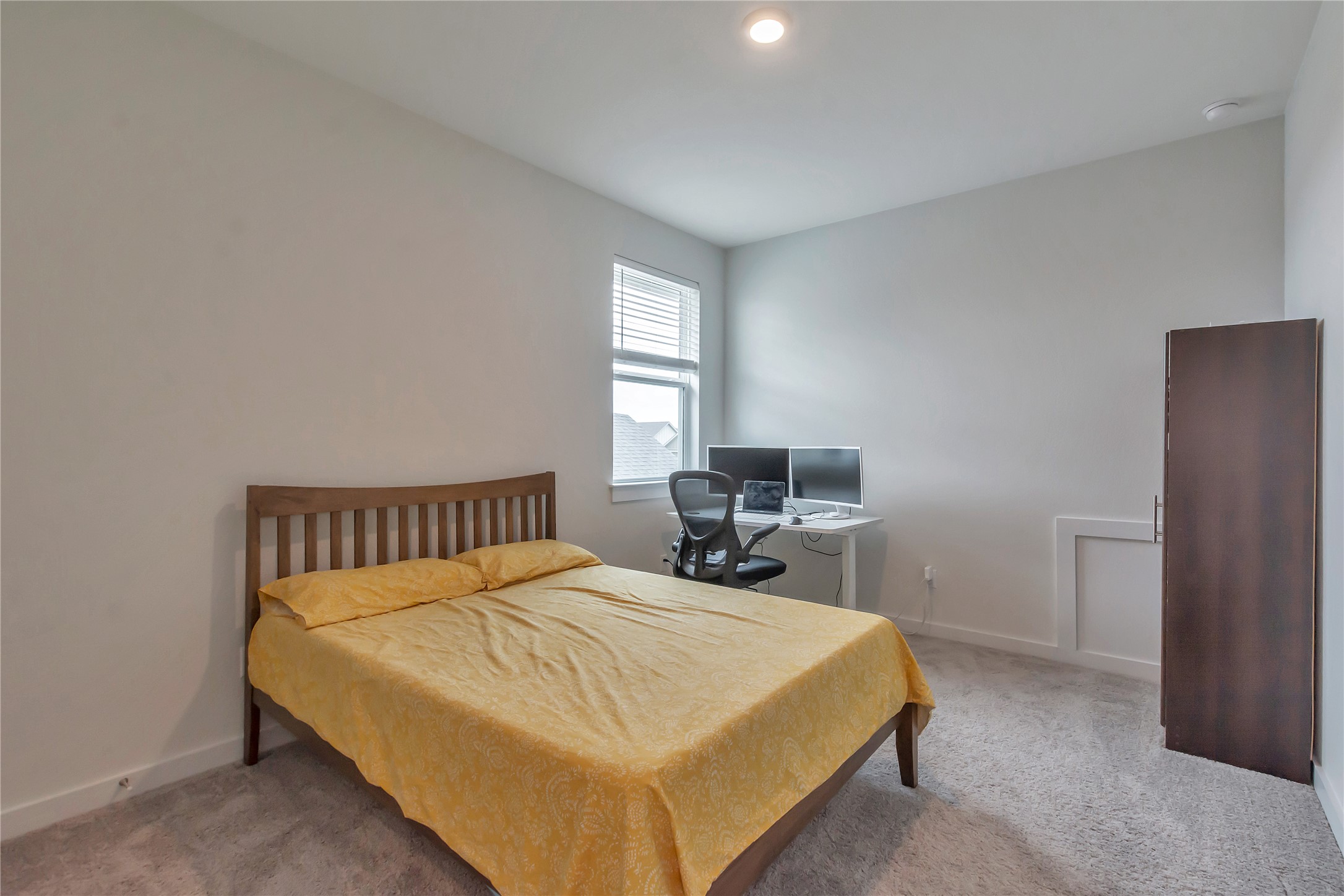 563 Saturnia Drive Georgetown, TX 78628 - Photo 17 of 29 a bed sitting in a bedroom next to a window with a sink and a chair
