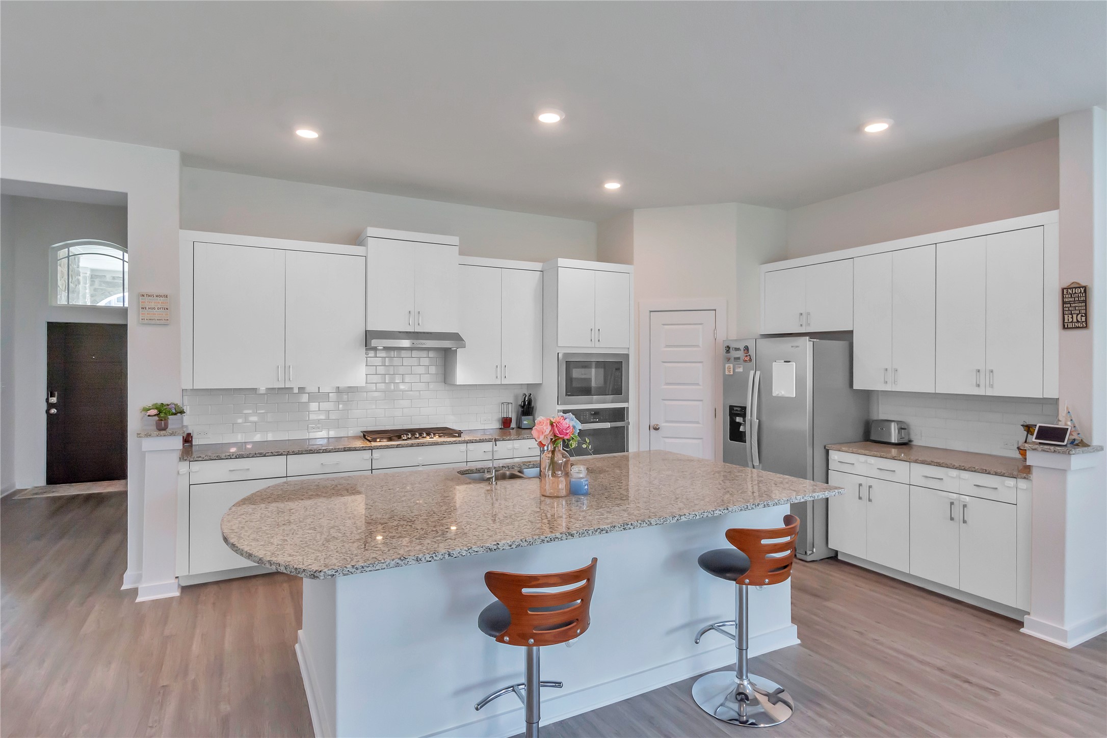 563 Saturnia Drive Georgetown, TX 78628 - Photo 6 of 29 a kitchen with stainless steel appliances granite countertop a stove a sink a refrigerator and white cabinets with wooden floor