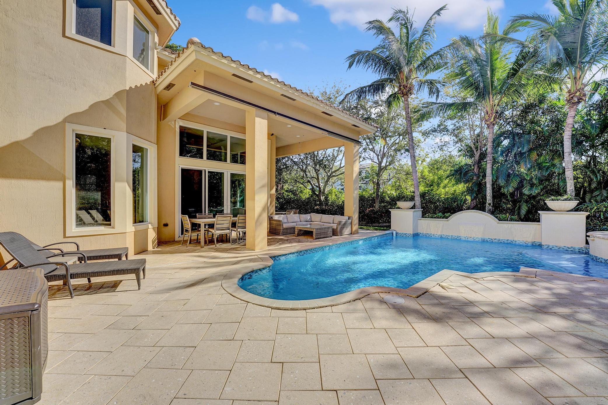 a view of a house with backyard and sitting area