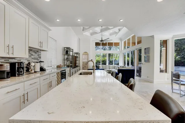 a kitchen with stainless steel appliances kitchen island granite countertop a table and chairs in it