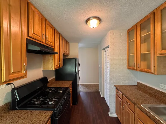 a kitchen with wooden cabinets and a stove top oven