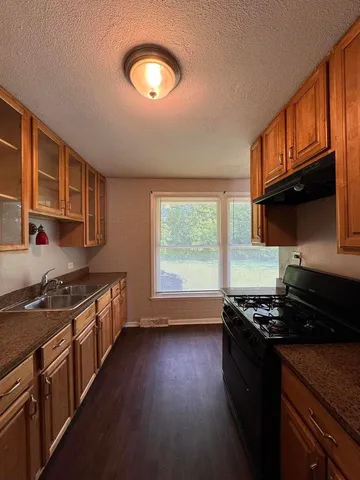 a kitchen with stainless steel appliances granite countertop a stove a sink and a microwave