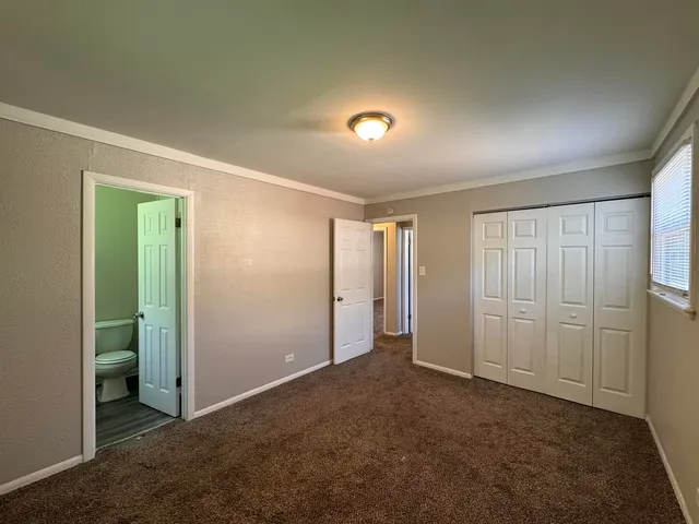 an empty room with closet and a bathroom