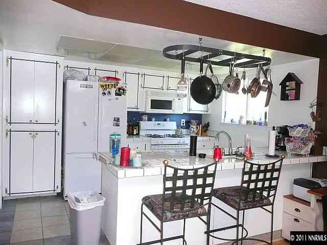 1810 Stardust Street Reno, NV 89503 - Photo 2 of 13 a kitchen with a refrigerator and cabinets