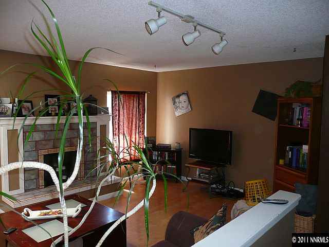 1810 Stardust Street Reno, NV 89503 - Photo 5 of 13 a living room with furniture a flat screen tv and floor to ceiling window