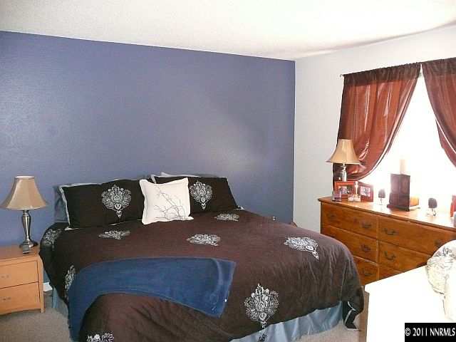 1810 Stardust Street Reno, NV 89503 - Photo 7 of 13 a bed sitting in a bedroom next to a window with lamp