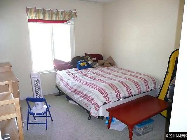1810 Stardust Street Reno, NV 89503 - Photo 8 of 13 a bedroom with a bed and chair