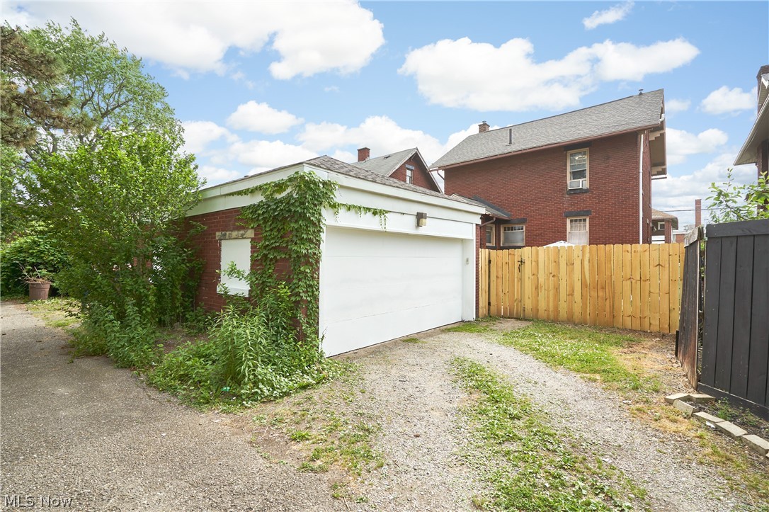 136 Smith Avenue Northwest Canton, OH 44708 - Photo 15 of 19 Detached garage with a white garage door, brick exterior, and a gravel driveway