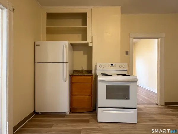 a white refrigerator freezer and a stove sitting inside of a kitchen