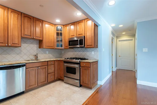 a kitchen with stainless steel appliances granite countertop wooden cabinets a sink and a stove