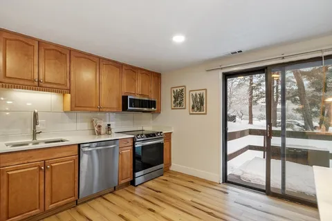 a kitchen with stainless steel appliances granite countertop a stove a sink and a microwave
