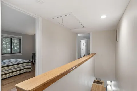 a view of a hallway with stairs and wooden floor