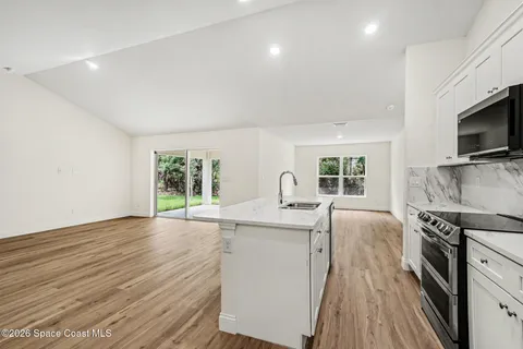 a kitchen with stainless steel appliances granite countertop a stove and a wooden floors