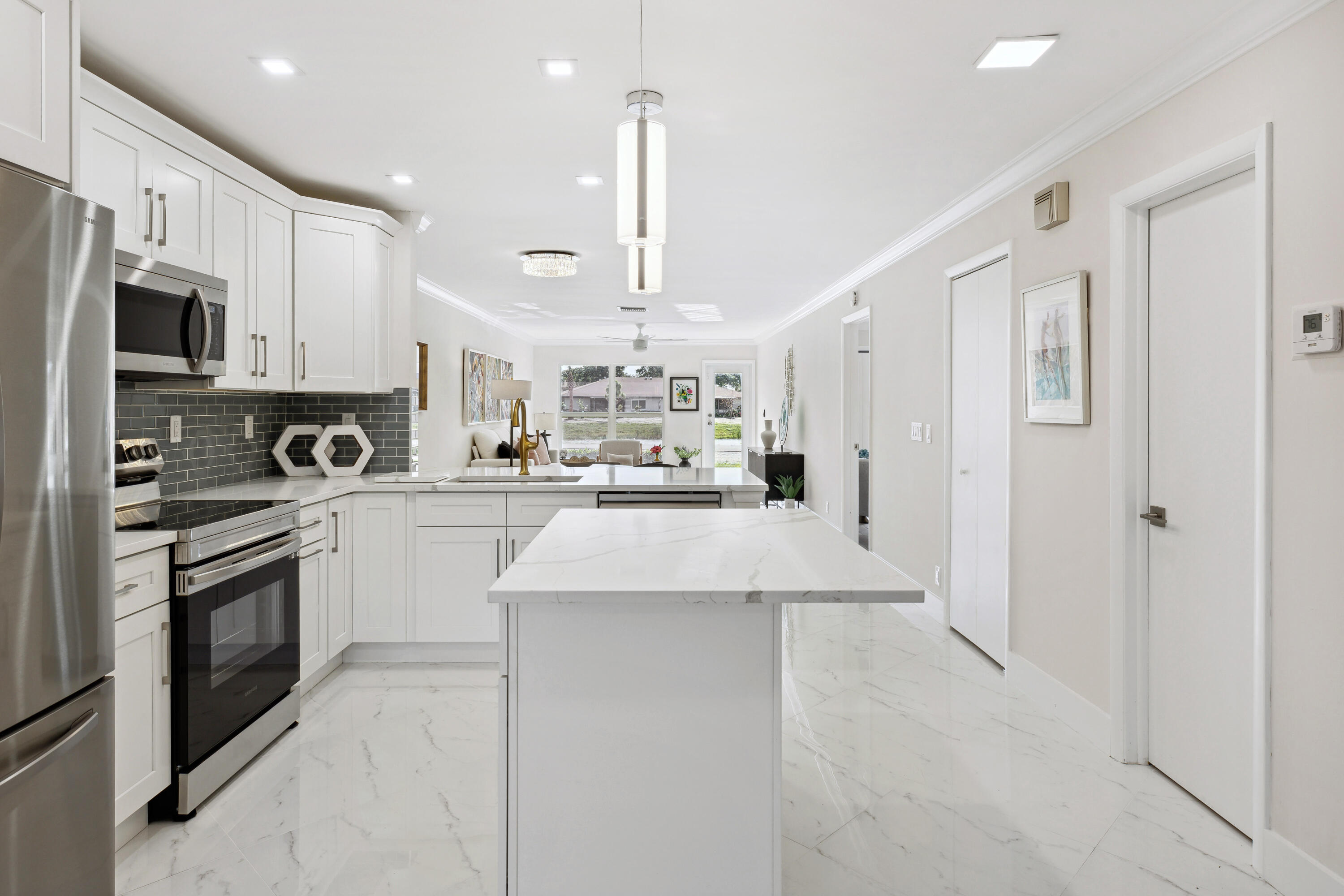 a kitchen with stainless steel appliances kitchen island granite countertop a refrigerator oven a sink dishwasher and white cabinets with wooden floor