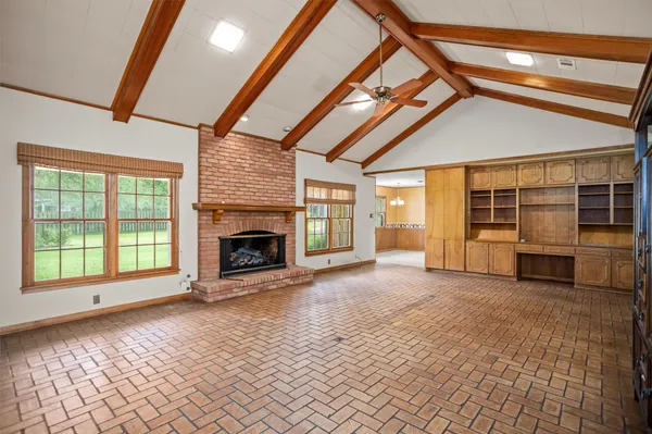 a view of an empty room with a fireplace and a window