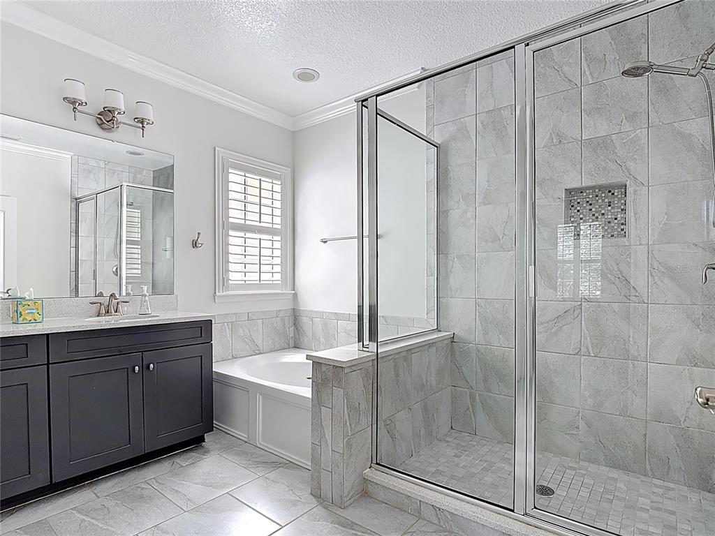 1513 Resolute Street Celebration, FL 34747 - Photo 28 of 43 a bathroom with a bathtub shower sink vanity and mirror
