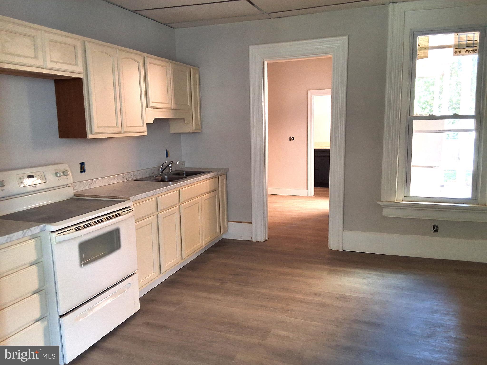 1015 Chestnut Street, Unit 1 Lebanon, PA 17042 - Photo 7 of 16 a kitchen with stainless steel appliances granite countertop a stove a sink and white cabinets with wooden floor