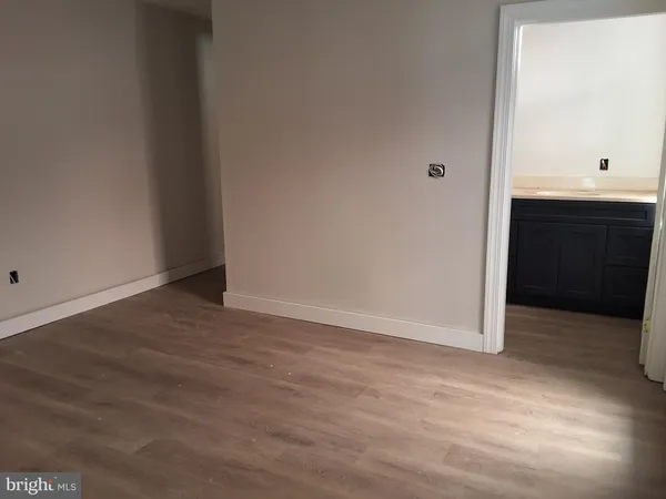 an empty room with wooden floor and cabinet