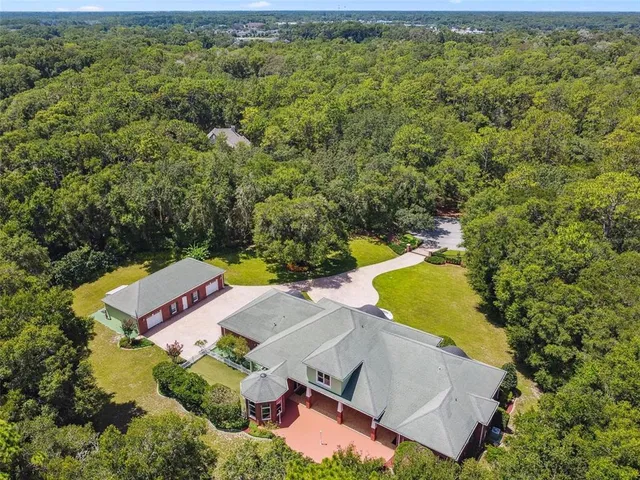 an aerial view of a house with a yard and swimming pool