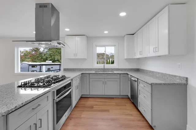 a kitchen with stainless steel appliances granite countertop a stove and a sink