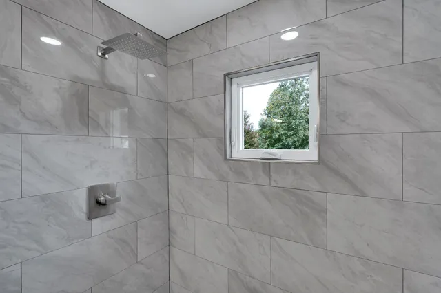 a bathroom with a window and a shower
