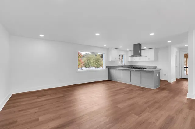 a view of kitchen with wooden floor and electronic appliances