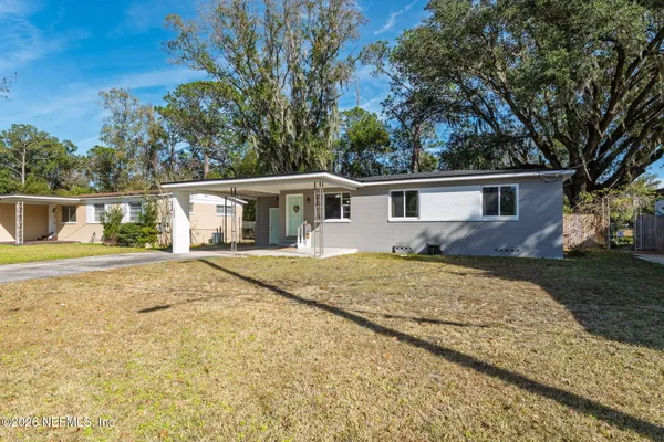 a front view of house with yard and trees around