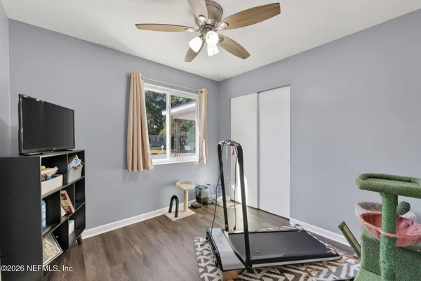 a backyard of a house with table and chairs under an large trees