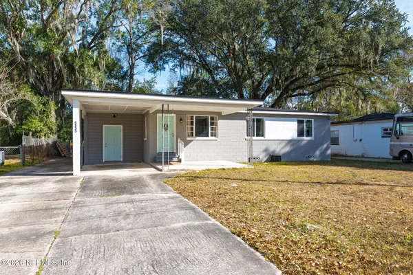 a front view of house with yard and trees around