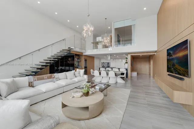 a living room with furniture kitchen view and a flat screen tv